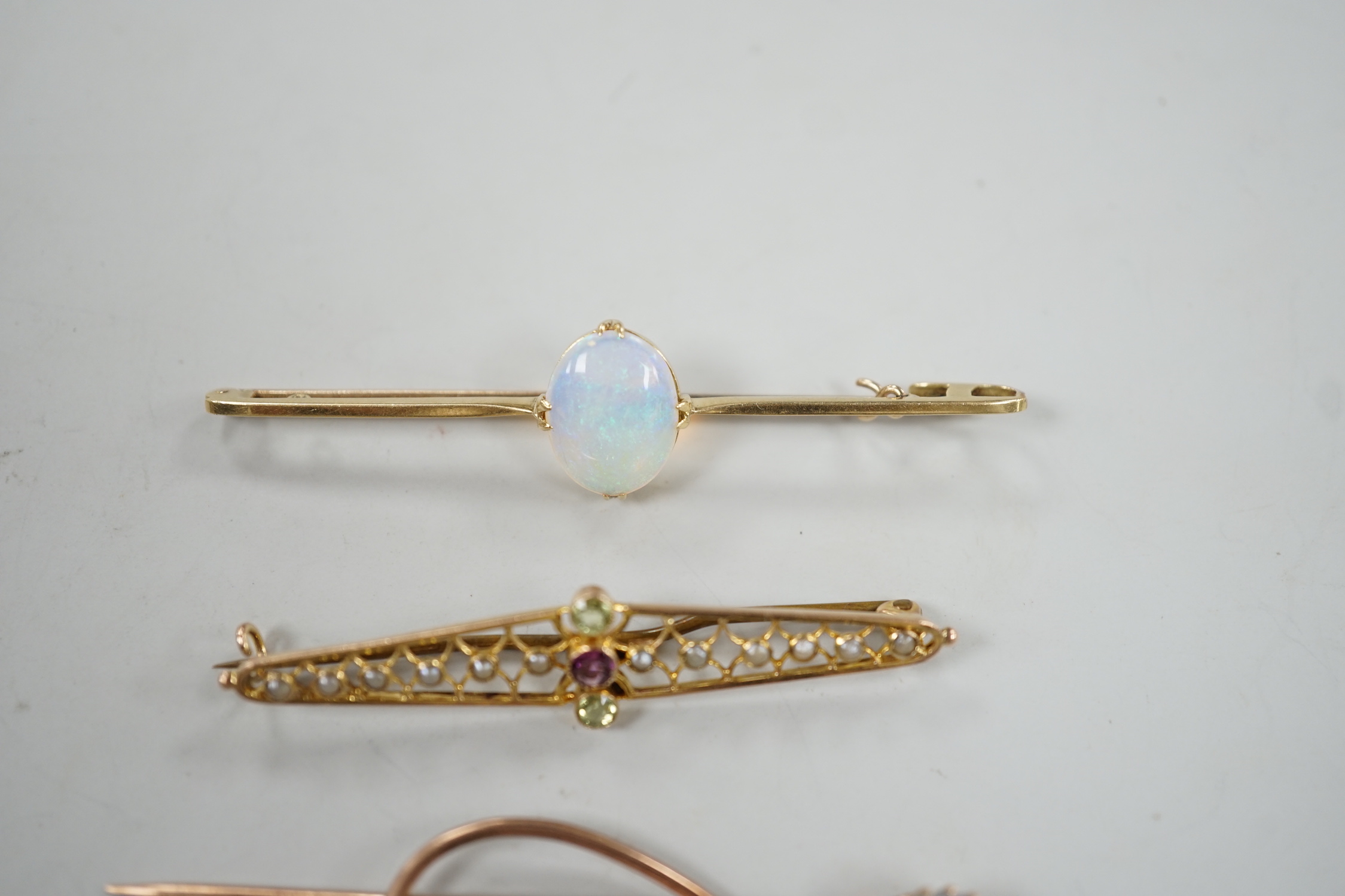 A novelty yellow metal, white opal and diamond set 'treble clef' stick pin, 60mm, a 15ct and white opal set bar brooch and one other 9ct and gem set brooch, gross weight 8.2 grams.